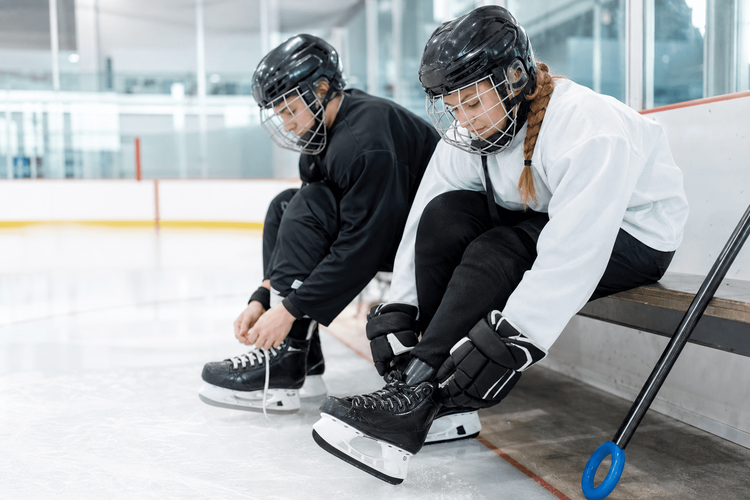Young Calgary hockey and ringette players lace their skates before practice for early-season injury prevention.